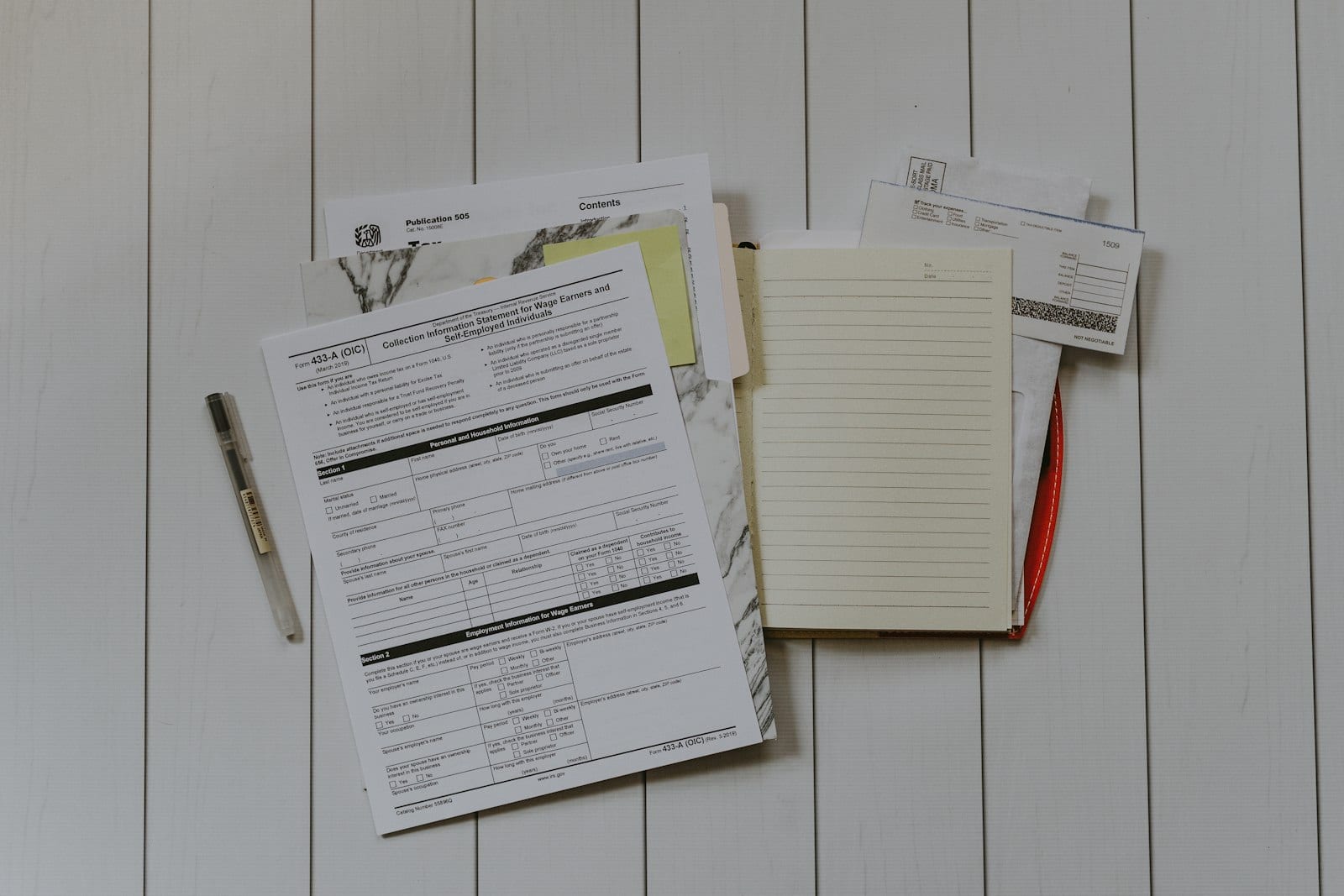 Notepad with debt-payoff calculations comparing avalanche and snowball
