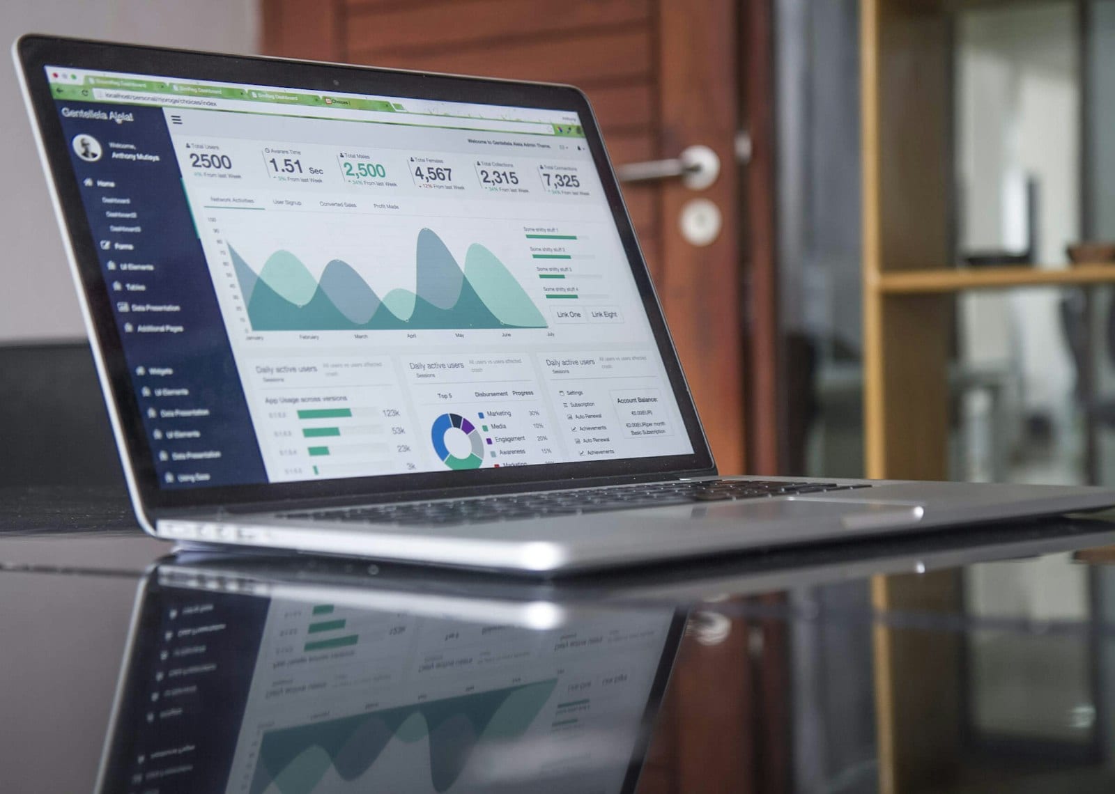Laptop with a budgeting spreadsheet next to a smartphone showing a personal finance app